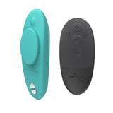 We-Vibe Moxie  remote controlled panty vibrator in teal. A three inch vibrator with a flat back  and rounded bottom. A small magnet attaches to the back. One button on the back. the small black remote control has four buttons.