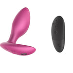 A small pink anal plug with a flat flared based that is longer in the front than the back. Has a magnetic charging connection on the bottom of the base. A black remote control with 5 buttons.