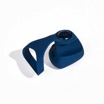 Dame Fin finger vibrator in navy. A small square shaped vibrator with rounded edges, a rounded bottom side, a fin on the top side to put between two fingers, and a button on the top side. There is a detachable silicone finger strap.
