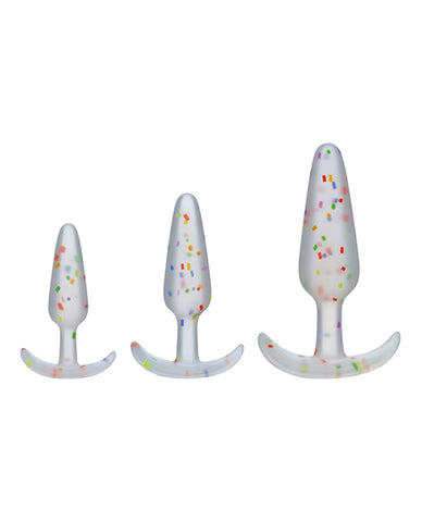 Mood Naughty Pride Confetti Trainer Kit. Three clear butt plugs with multicolored specs, in small, medium, and large. Each has a tapered tip, slim neck, and curved flared base