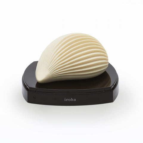 Tenga Iroha Kushi Textured vibrator. A cream colored palm-sized vibe with a flat bottom side and rounded top with ribbed texture. Has a small pointed tip on the side. Two button controls on the bottom side.