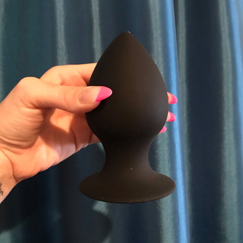 F-98 Large Anal Butt Pug. A wide black, teardrop-shaped butt plug with thick neck and round flared base